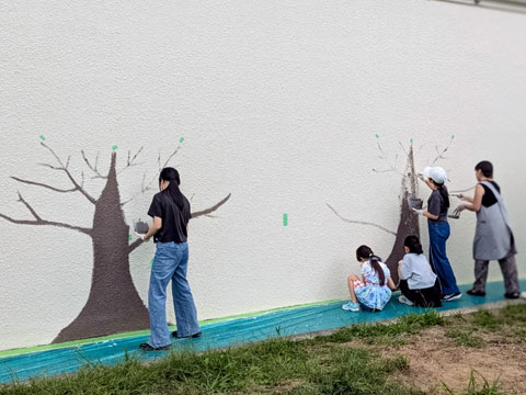 保護者有志と児童で幹部分を先に描いています（2025年10月21日高槻市立安岡寺小学校50周年記念手形アート塗装）