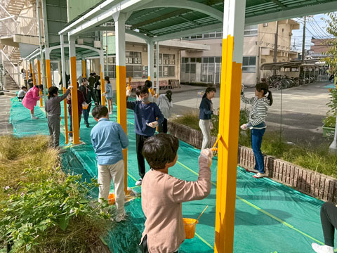 渡り廊下の高い箇所は職人が担当しました（2025年11月4日高槻市立阿武野小学校ボランティア塗装）