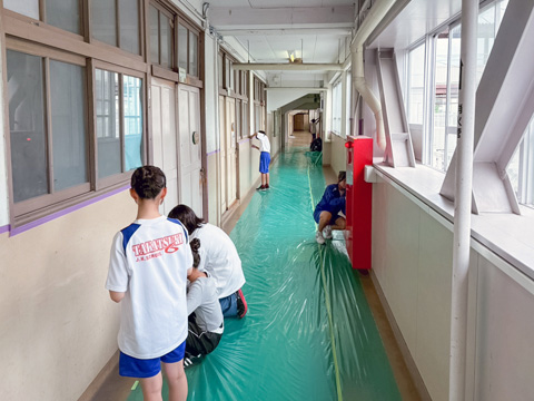 養生シートを塗り替える周囲に貼っていきます（2026年6月高槻市第六中学校職場体験）