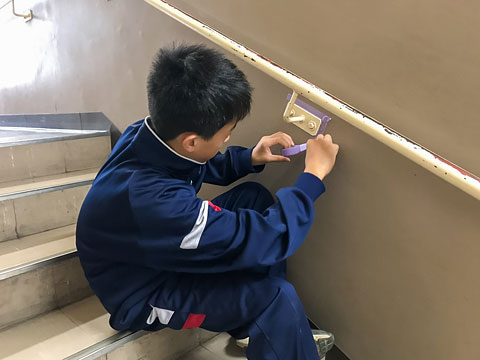 参加生徒が手摺りの細かい箇所まで養生を行っているところ（2019年10月24日 阿武山中学校）