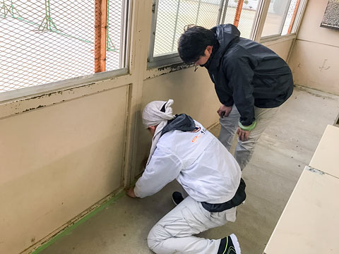 職人が傍で見守りつつ、生徒さんが養生テープを貼ります（2019年1月31日　川西中学校）