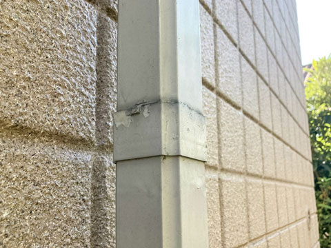 紫外線や雨水などの影響で付帯物(雨樋)の表面塗膜が劣化し、撥水機能が低下したため汚れが付着しています。また、一部塗膜が剥離しています。