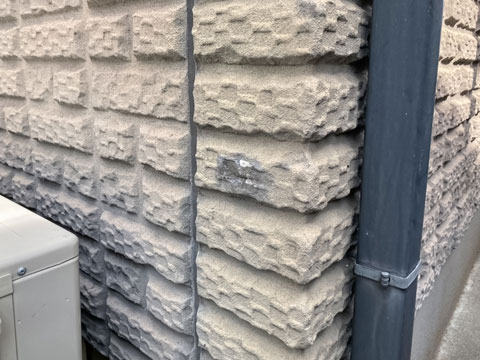 衝撃や雨水などで外壁表面塗膜が捲れることによって雨水が染み込み、汚れが付着しています。