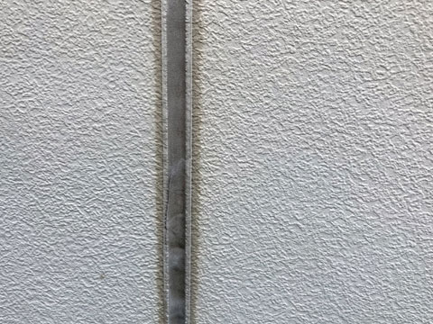 紫外線や雨水などの影響によって外壁目地のコーキングが劣化し、表面が黒ずむブリード現象が発生しています。